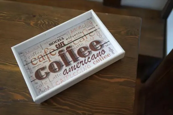 White tray with "coffee" lettering on a wooden table