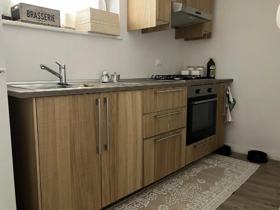 Kitchenette with hob, oven, sink and wood-effect units