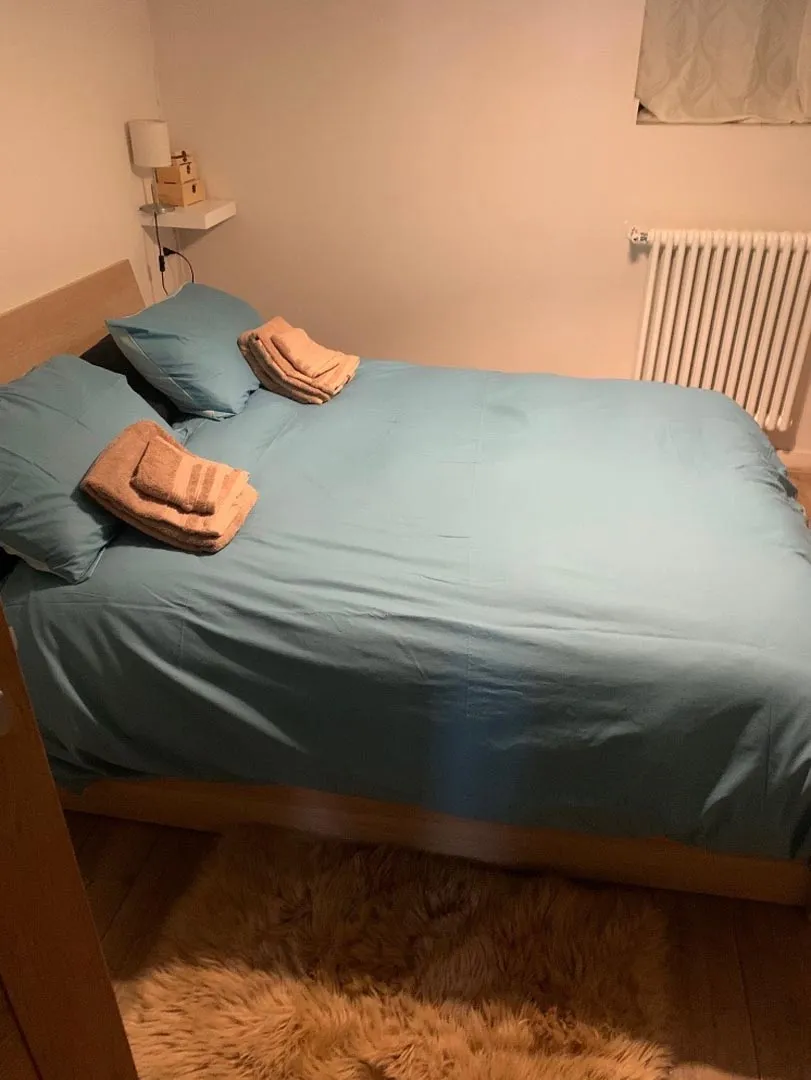 Double bedroom with light-blue bedding, fresh towels and a soft rug