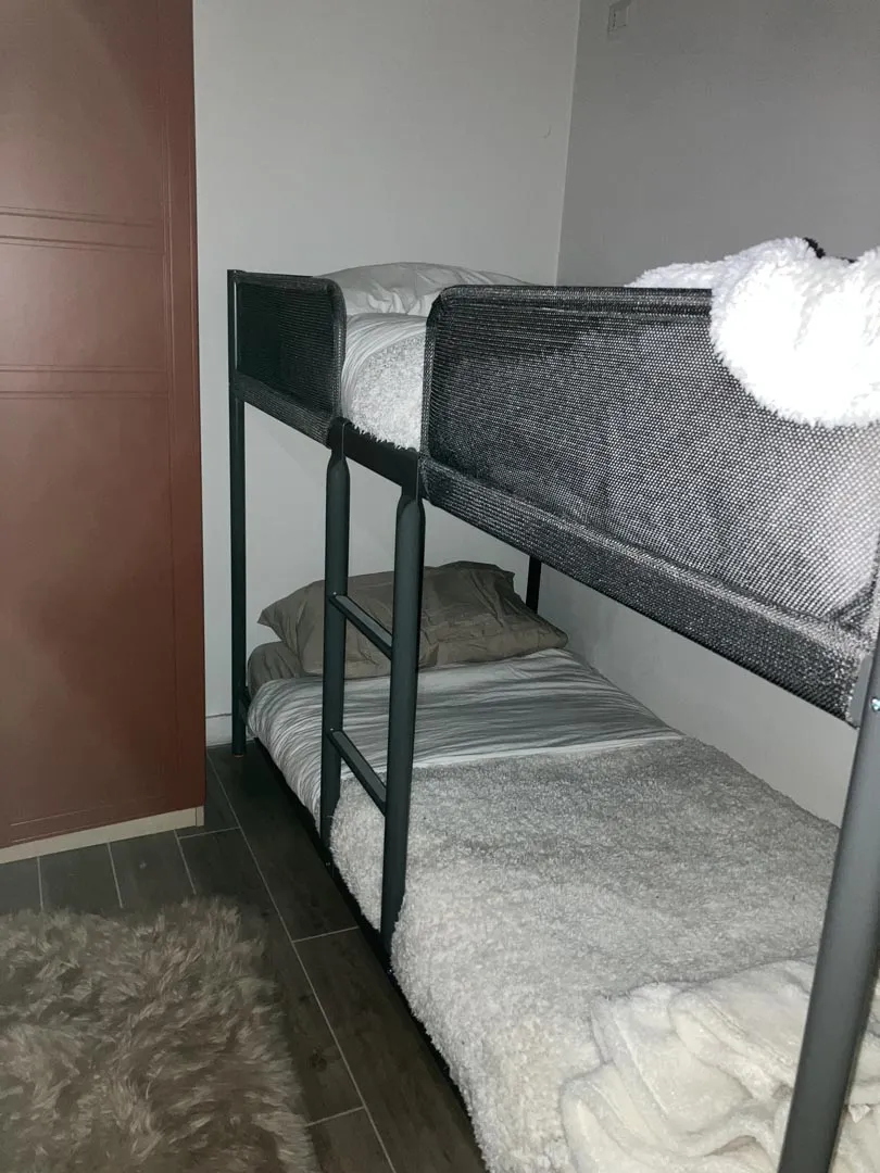 Metal bunk bed with white bedding and soft blankets
